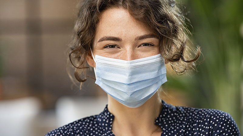 Mulher de máscara por causa de pandemia de Covid-19