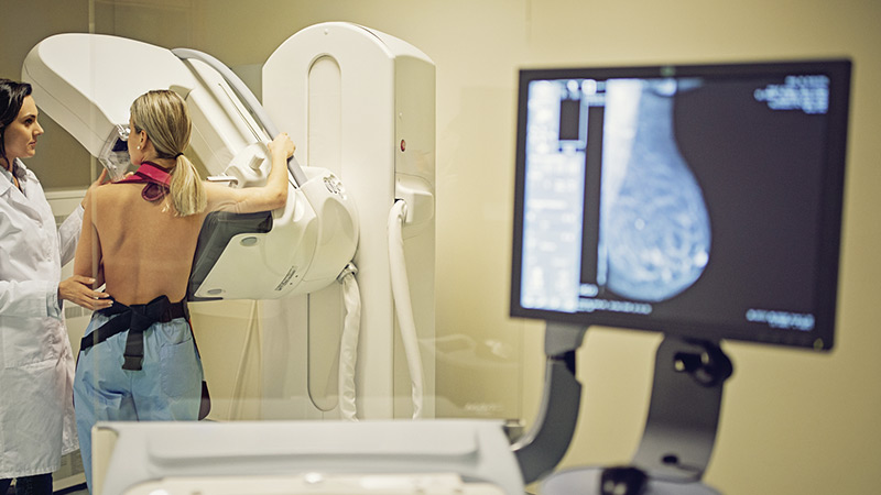Médico está trabalhando com scanner de raios-X de mamografia no hospital