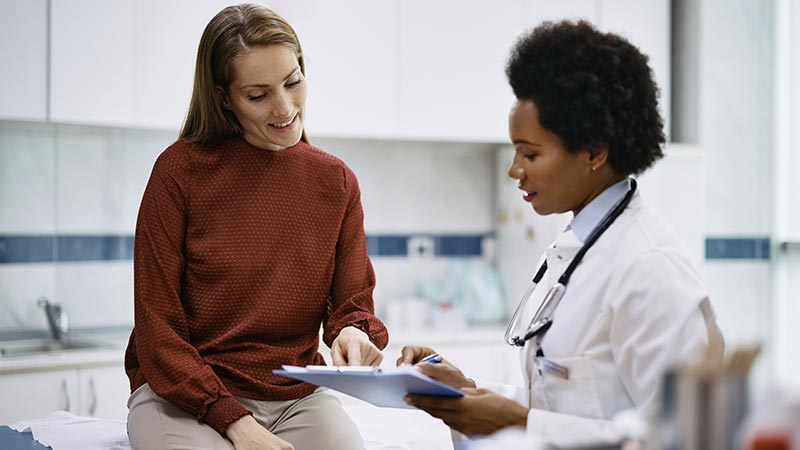 Médica e paciente conversando sobre exame de mama