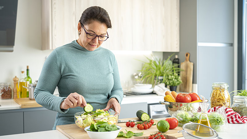 Mulher preparando uma alimentação saudável em sua cozinha