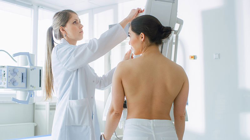 Paciente do sexo feminino fazendo mamografia procedimento feito pelo tecnólogo de mamografia de rastreio