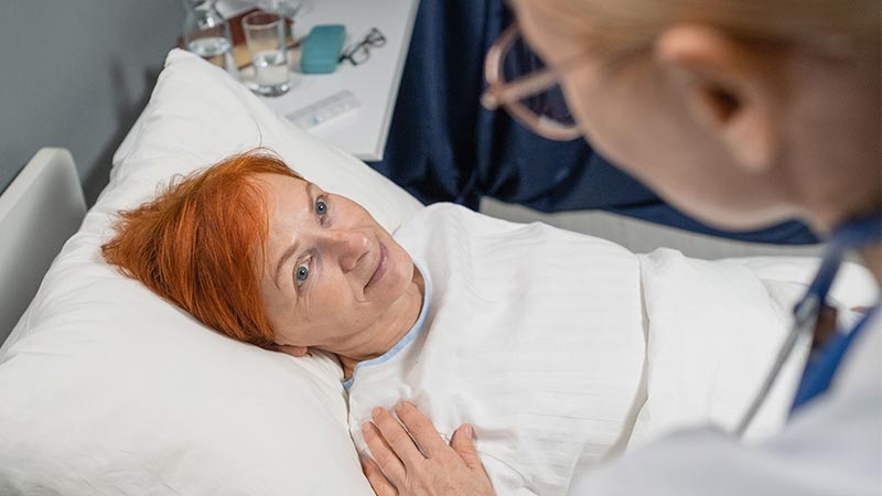 Mulher idosa conversando com médico após a cirurgia de mama