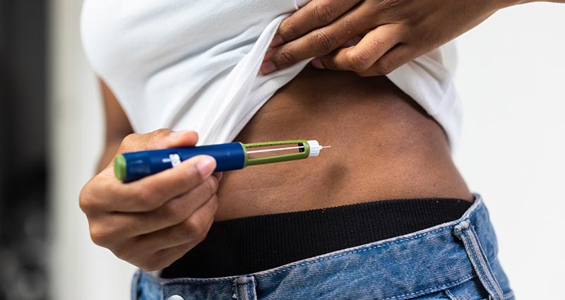 Aplicando medicamento de caneta emagrecedora na barriga