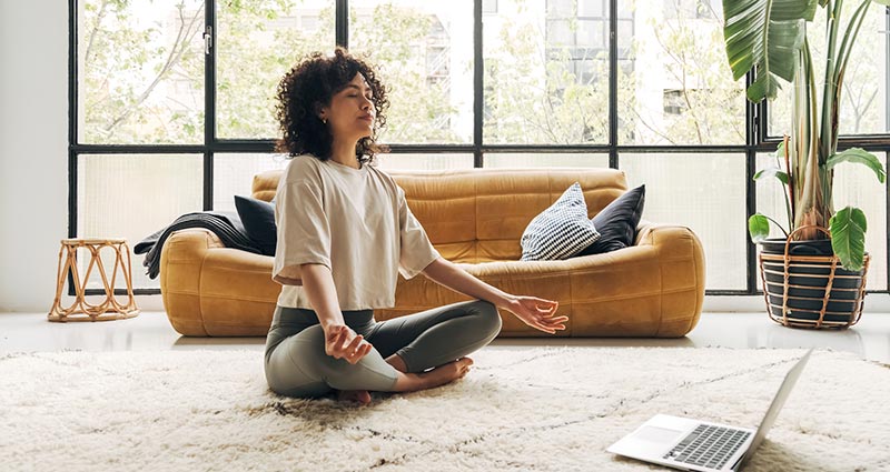 Mulher meditando na sala de estar